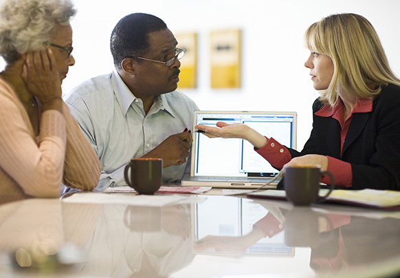 A couple sitting at a table talking to their agent