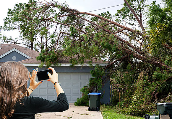 Person photographing damage to house