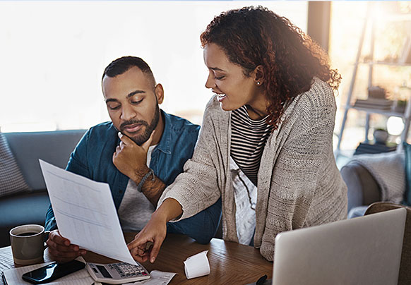 A couple reviewing documents with laptop
