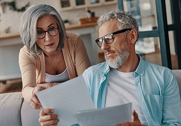 Couple reviewing documents comparing home warranty vs insurance
